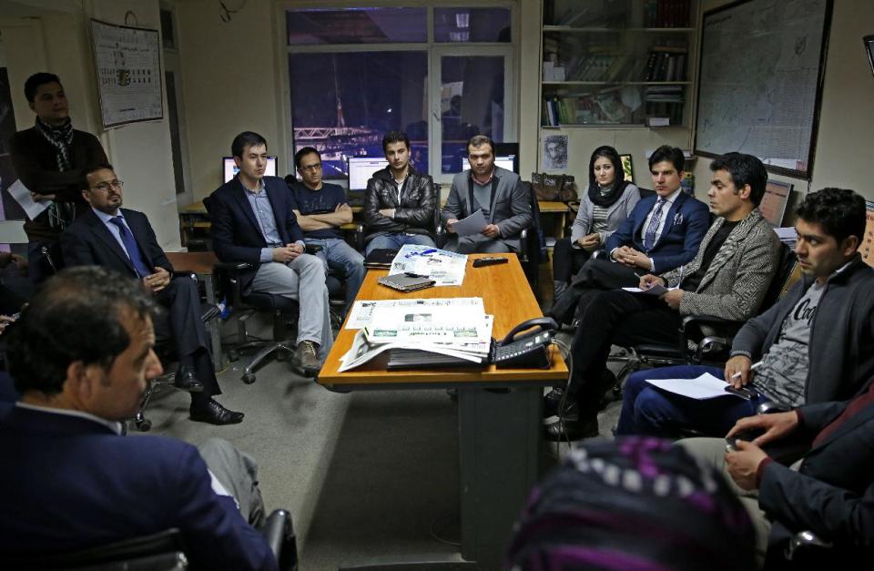 In this Monday, Feb. 3, 2014 photo, Tolo TV staffers talk during a meeting at their office in Kabul, Afghanistan. The proliferation of Afghan media in the past 12 years is one of the most visible bright spots of the fraught project to foster a stable democracy. (AP Photo/Massoud Hossaini)