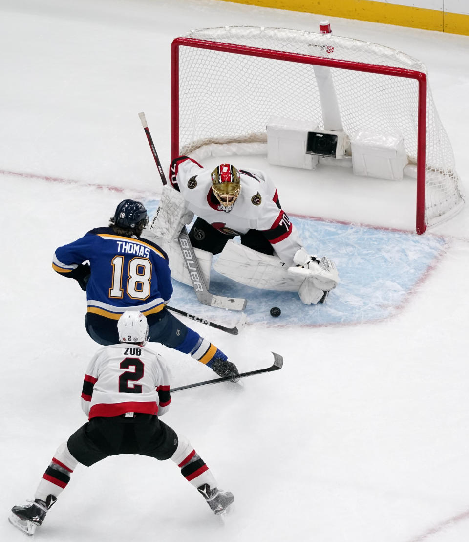 St. Louis Blues' Robert Thomas (18) scores as Ottawa Senators goaltender Joonas Korpisalo and Artem Zub (2) defend during the first period of an NHL hockey game Thursday, Dec. 14, 2023, in St. Louis. (AP Photo/Jeff Roberson)