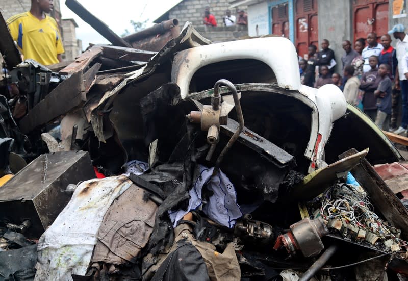 Civilians gather at the site where a Dornier 228-200 plane operated by local company Busy Bee crashed into a densely populated neighborhood in Goma