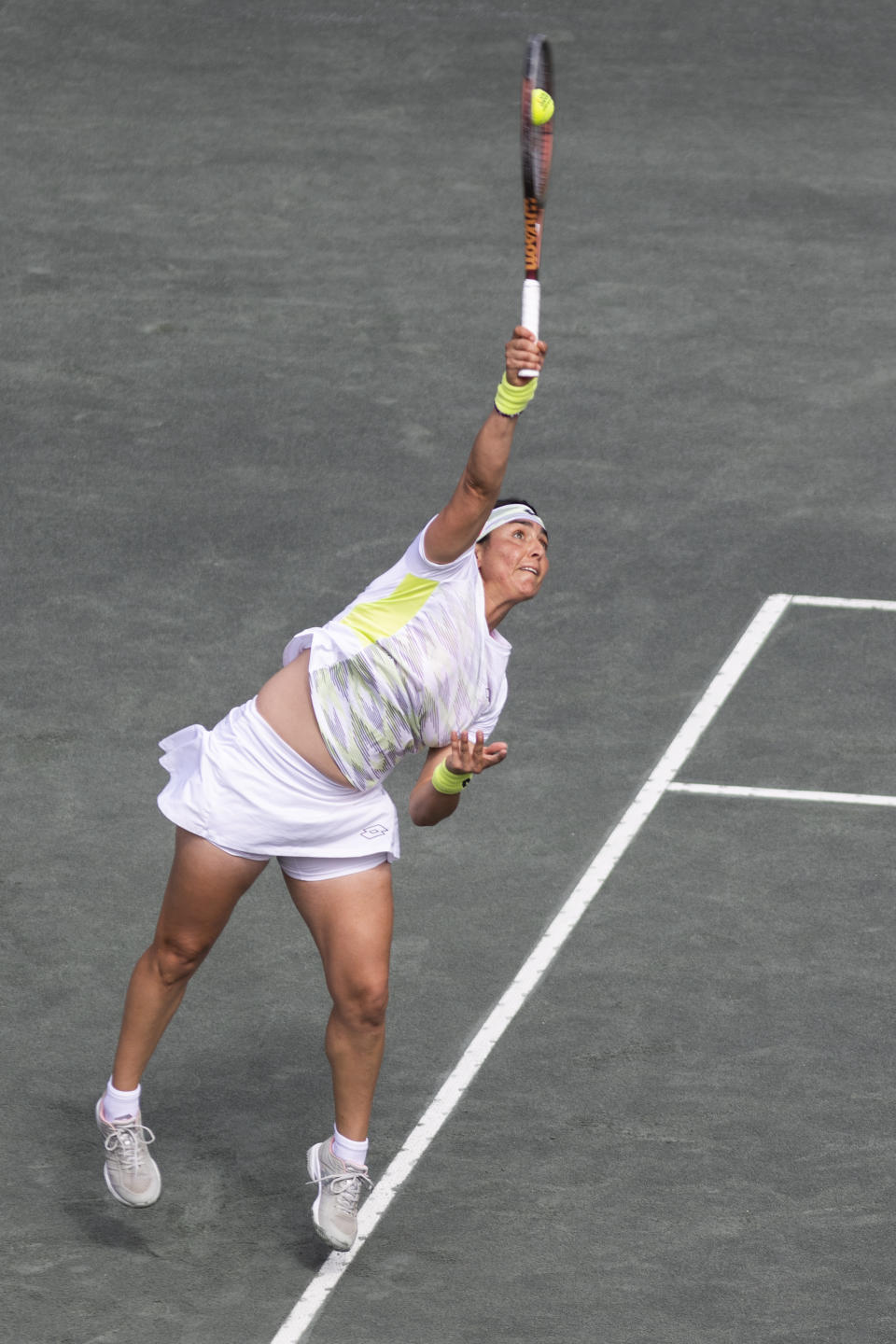 Ons Jabeur, of Tunisia, serves to Belinda Bencic, of Switzerland, during the championship match at the Charleston Open tennis tournament in Charleston, S.C., Sunday, April 9, 2023. (AP Photo/Mic Smith)