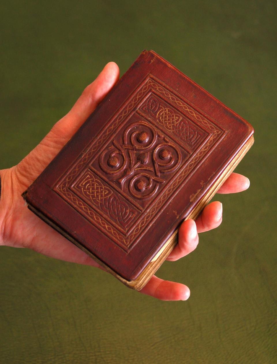 This photo, released by The British Library Tuesday April 17 2012, , shows the St. Cuthbert Gospel, a remarkably preserved palm-sized book which is a manuscript copy of the Gospel of John in Latin which was bought from the British branch of the Society of Jesus (the Jesuits), the library said Tuesday April 17, 2012. The small book - 96 mm (3.8 inches) by 136 mm (5.4 inches) - has an elaborately tooled red leather cover. It comes from the time of St. Cuthbert, who died in 687, and it was discovered inside his coffin at Durham Cathedral when it was reopened in 1104.  (AP Photo / The British Library)