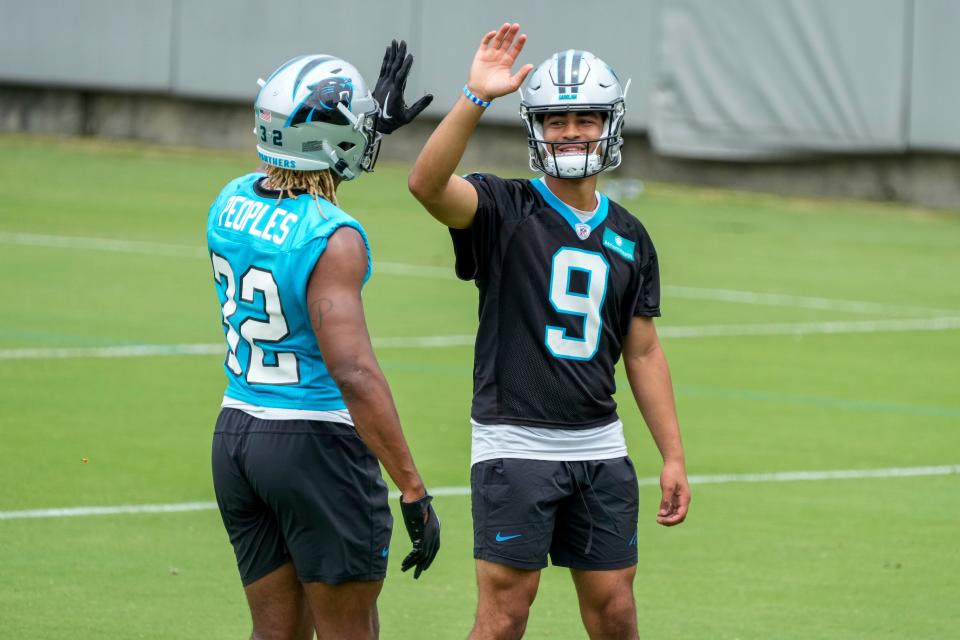 Carolina Panthers quarterback Bryce Young (9) high fives running back Camerun Peoples (32) during the Carolina Panthers minicamp.