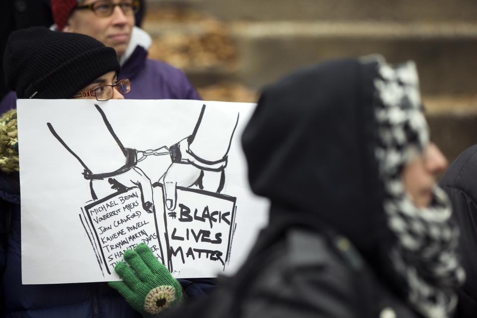 A demonstrator holds a sign before marching to City Hall to protest a grand jury's decision not to indict white police officer Darren Wilson for killing unarmed black teenager Michael Brown, in St. Louis, Missouri November 26, 2014. (REUTERS/Lucas Jackson)