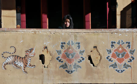 A girl looks from the balcony of a shop in the capital city of Thimphu, Bhutan, December 11, 2017. REUTERS/Cathal McNaughton