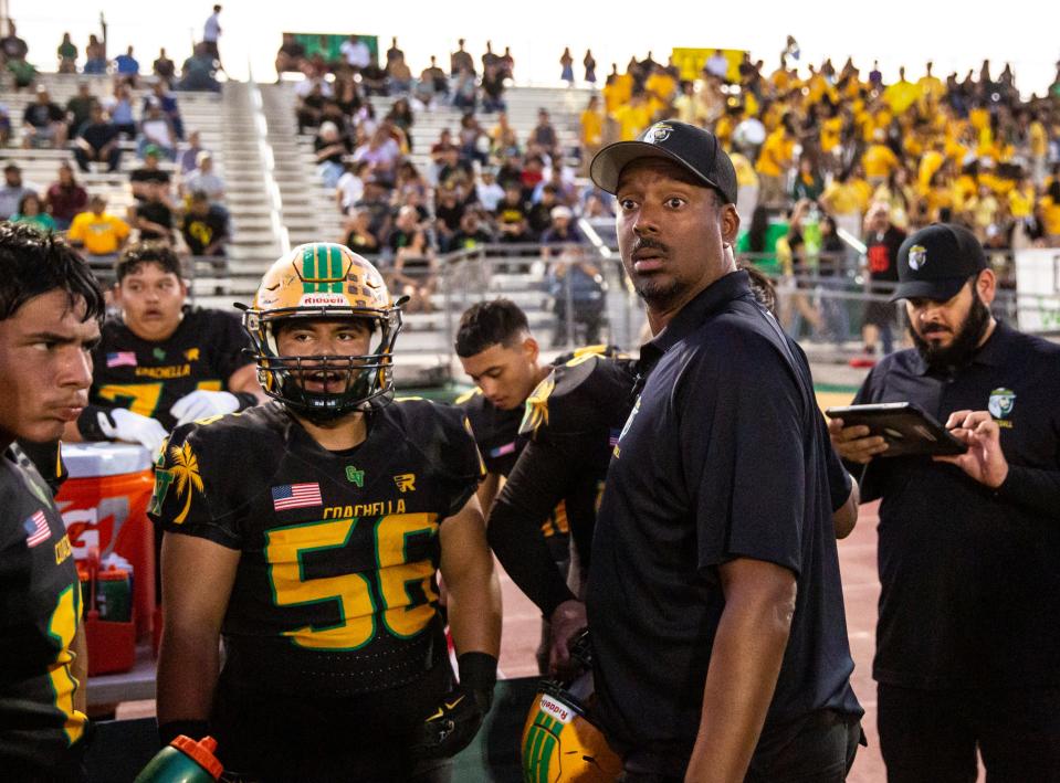 Coachella Valley Head Coach Bill Johnson talks with his offense during the first quarter of their game at Coachella Valley High School in Thermal, Calif., Friday, Sept. 15, 2023.