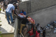 Rescue workers move a body from the site after a Pakistan International Airlines aircraft after crashed at a residential area in Karachi on May 22, 2020. - A Pakistan passenger plane with more than 100 people believed to be on board crashed in the southern city of Karachi on May 22, the country's aviation authority said. (Photo by Asif HASSAN / AFP) (Photo by ASIF HASSAN/AFP via Getty Images)