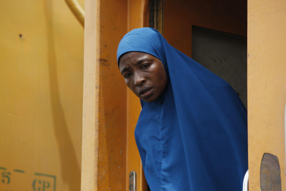 In this Photo taken, Friday, March . 8, 2013, a Muslim women peers out the door aboard an Ooni of Ife train to Kano, in Nigeria. Nigeria reopened its train line to the north Dec. 21, marking the end of a $166 million project to rebuild portions of the abandoned line washed out years earlier. The state-owned China Civil Engineering Construction Corp. rebuilt the southern portion of the line, while a Nigerian company handled the rest. The rebirth of the lines constitutes a major economic relief to the poor who want to travel in a country where most earn less than $1 a day. Airline tickets remain out of the reach of many and journeys over the nation's crumbling road network can be dangerous. The cheapest train ticket available costs only $13. ( AP Photo/Sunday Alamba)