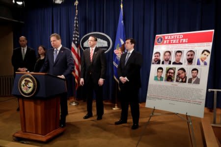 FILE PHOTO: U.S. Deputy Attorney General Rod Rosenstein listens to Attorney Geoffrey Berman for the Southern District of New York speaking at a news conference with other law enforcement officials at the Justice Department to announce nine Iranians charged with conducting massive cyber theft campaign, in Washington, U.S., March 23, 2018. REUTERS/Yuri Gripas