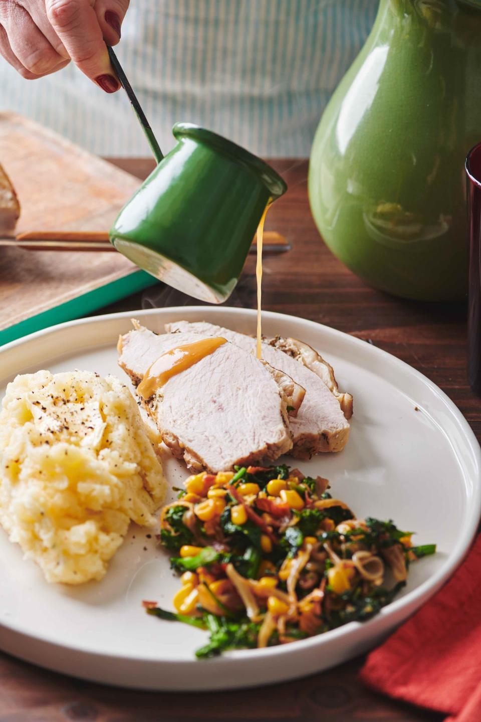 In this May 2019 photo gravy is poured on a plate of turkey, mash potatoes and gravy and a side of sauteed broccoli rabe, corn and onions with crispy bacon, on a table in New York. If you remember that the turkey breast will take less time to cook than the legs, and that you can get a head start on your gravy, Thanksgiving will be a whole lot less stressful. (Cheyenne Cohen/Katie Workman via AP)