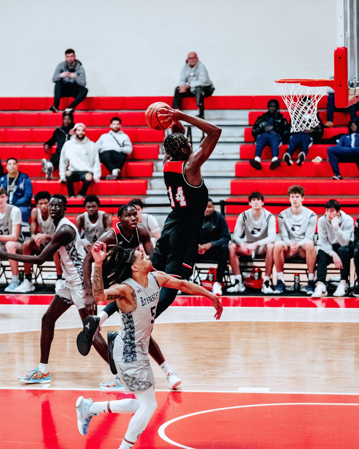 Putnam Science Academy's Oswin Erhunmwunse soars for a dunk against Brewster Academy in March, 2023.