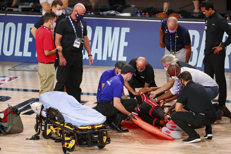 Miami Heat forward Derrick Jones Jr. (5) is tended to by medical personnel after colliding with Indiana Pacers center Goga Bitadze (not pictured) during the second half of an NBA basketball game Friday, Aug. 14, 2020, in Lake Buena Vista, Fla. (Kim Klement/Pool Photo via AP)