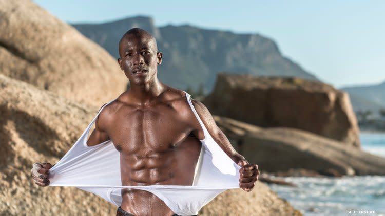 Black man rips off shirt on beach