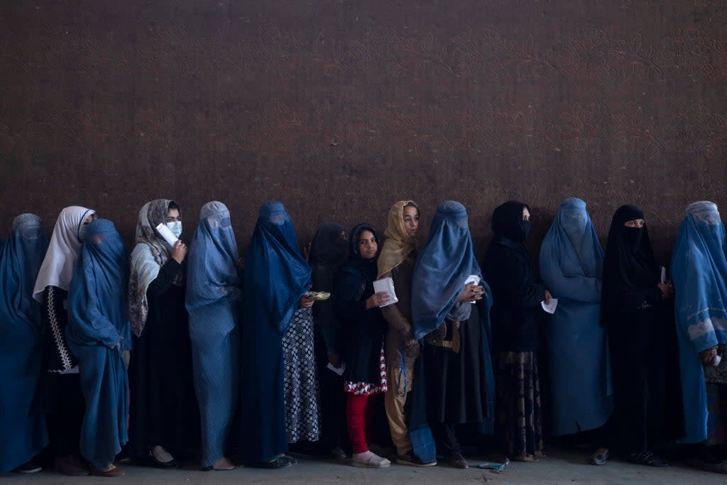 Women queuing to get cash at a money distribution point organized by the World Food Programme in Kabul  (AP)