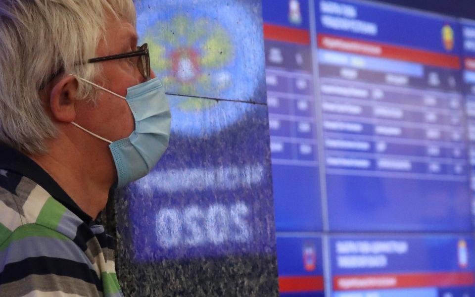 A man stands next to a screen displaying preliminary voting results - Sergei Fadeichev\\TASS via Getty Images