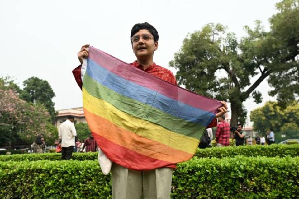 An activist holds a rainbow flag in the courtyard of India’s Supreme Court in New Delhi on 17 October 2023 (AFP via Getty)