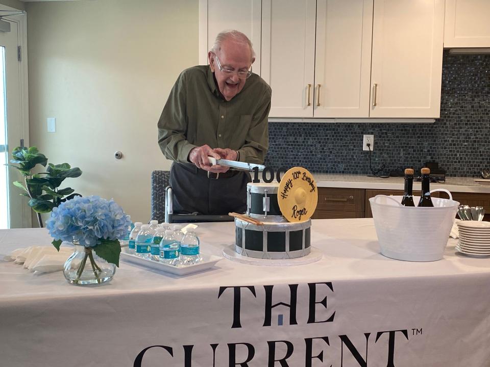 A man cuts his 100th birthday cake