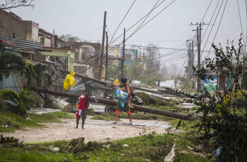 <p>Dos residentes caminan cerca de líneas y postes de electricidad derribados por el huracán Irma, en Caibarién, Cuba, el sábado 9 de septiembre de 2017. (AP Foto/Desmond Boylan) </p>