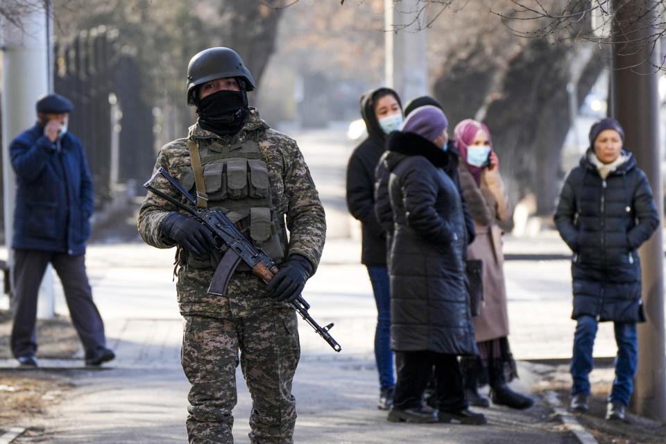 FILE - A Kazakhstan soldier patrols a street as relatives of the arrested after anti-government protests gather near a police station in Almaty, Kazakhstan, Friday, Jan. 14, 2022. With about 12,000 people arrested after anti-government protests in Kazakhstan last week, friends and relatives of those held by police waited outside a jail, hoping to learn their fate. According to figures released by the Kazakh Prosecutor General's office, 238 people were killed in the January unrest. Rights campaigners have criticized the government-published list of victims for not clarifying the circumstances of their deaths. (AP Photo/Sergei Grits, File)