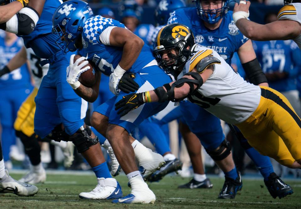 Kentucky running back JuTahn McClain is stopped by Iowa linebacker Jack Campbell during the first quarter of the TransPerfect Music City Bowl at Nissan Stadium, Dec. 31, 2022, in Nashville, Tenn.