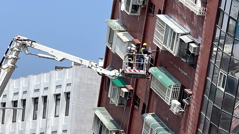 花蓮強震造成花蓮市區天王星大樓傾斜，台灣省土木技師公會人員4日乘坐高空吊臂，從外牆逐樓鑽探採樣。（中央社）