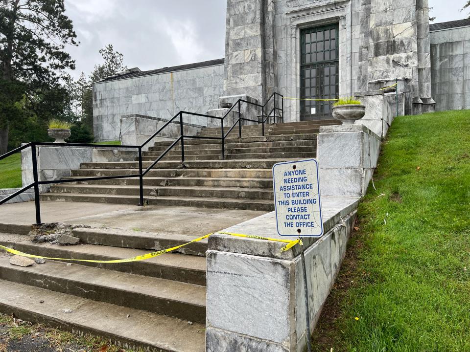 A photo provided by Nancy Vogl to the State Journal shows caution tape stretched across crumbling steps on the exterior of a mausoleum at DeepDale Memorial Gardens, a privately-owned cemetery in Delta Township.