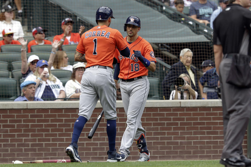 Houston Astros' Carlos Correa celebrates with teammate Jason Castro after scoring a run during the second inning of a baseball game against the Seattle Mariners, Wednesday, July 28, 2021, in Seattle. (AP Photo/Jason Redmond)