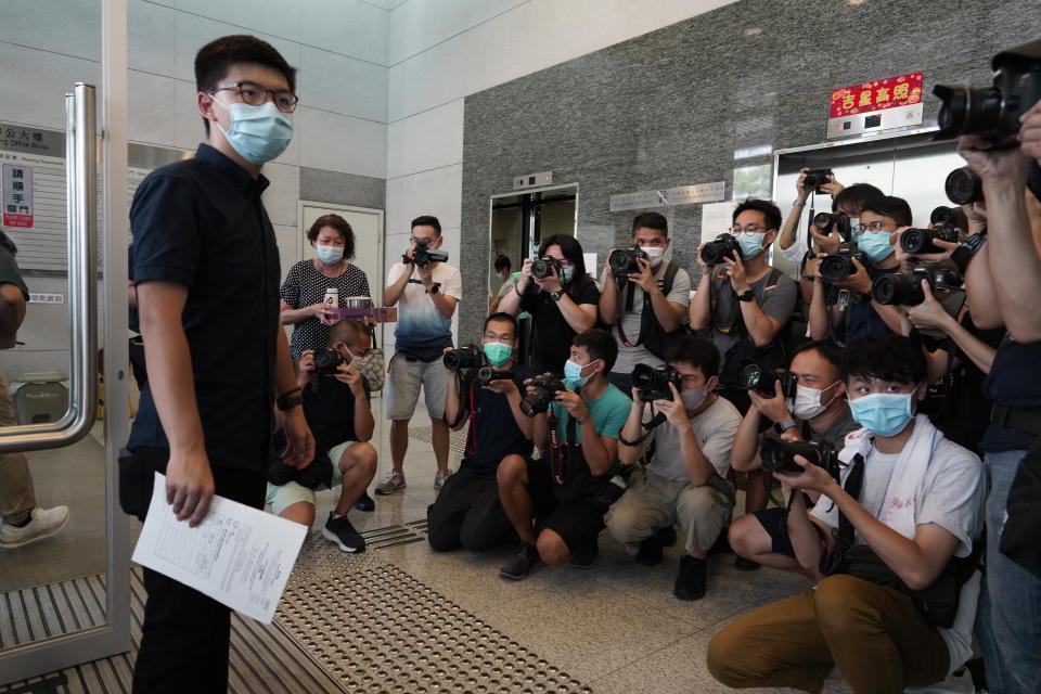 Hong Kong pro-democracy activist Joshua Wong poses with the nomination papers as he files for his candidacy in the Legislative Council elections in September in Hong Kong, Monday, July 20, 2020. At least 12 Hong Kong pro-democracy nominees including Joshua Wong were disqualified for a September legislative election, with authorities saying Wednesday, July 29, they failed to uphold the city's mini-constitution and pledge allegiance to Hong Kong and Beijing. (AP Photo/Vincent Yu)