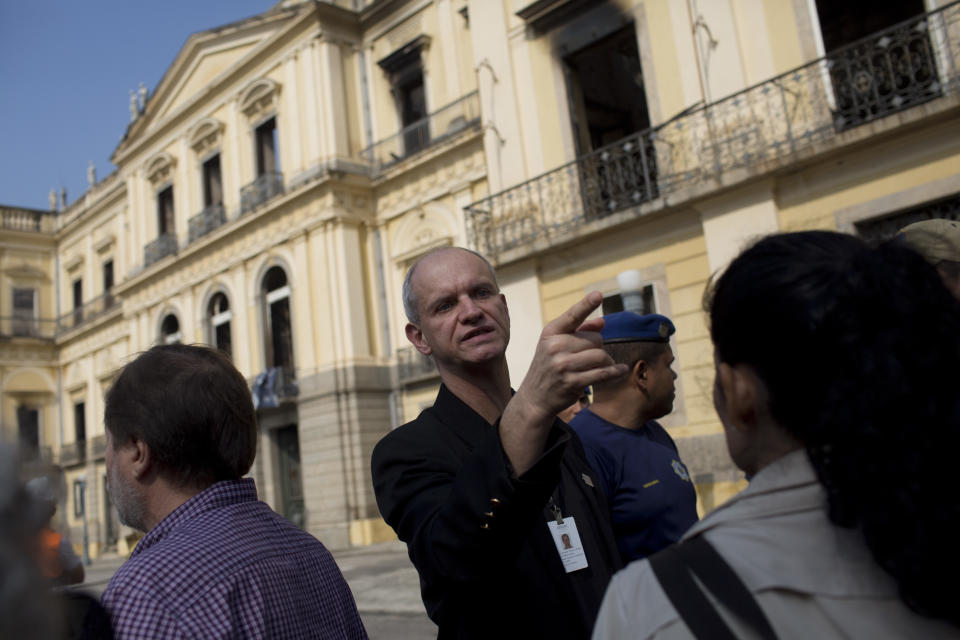 National Museum Director Alexander Kellner talks with his personnel after an overnight fire at the museum in Rio de Janeiro, Brazil, Monday, Sept. 3, 2018. The esteemed museum houses artifacts from Egypt, Greco-Roman art and some of the first fossils found in Brazil. (AP Photo/Silvia Izquierdo)