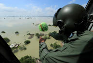 <p>An Indian Air Force official drops relief materials to people affected by floods in Allahabad, India, Wednesday, Aug. 24, 2016. (AP Photo/Rajesh Kumar Singh)</p>