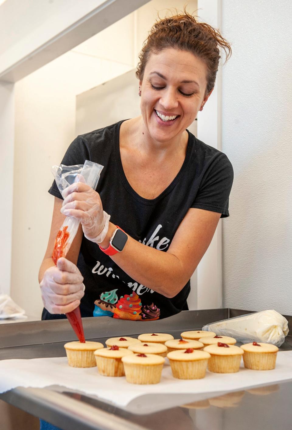 Kristin Littlefield, at Maine Girl Cupcakes in Natick, creates cheesecake cupcakes inside her new downtown storefront, Dec. 14, 2022. 