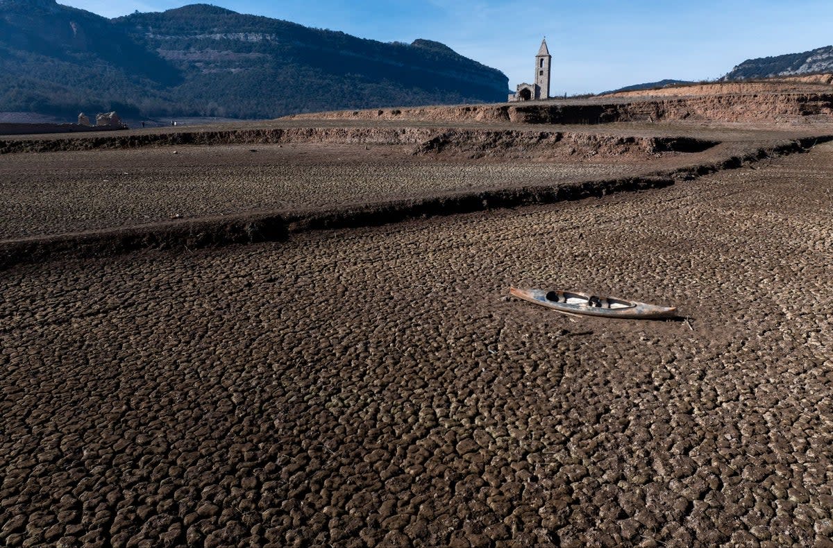 An abandoned kayak lies on the cracked ground at the Sau reservoir near Catalonia (AP)