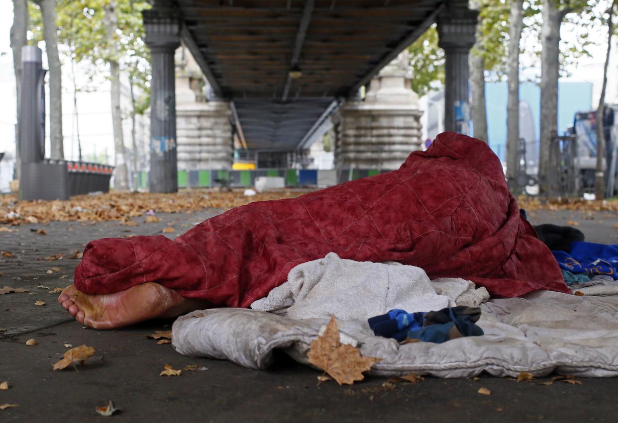 A homeless migrant asleep on a Paris street (Rex)