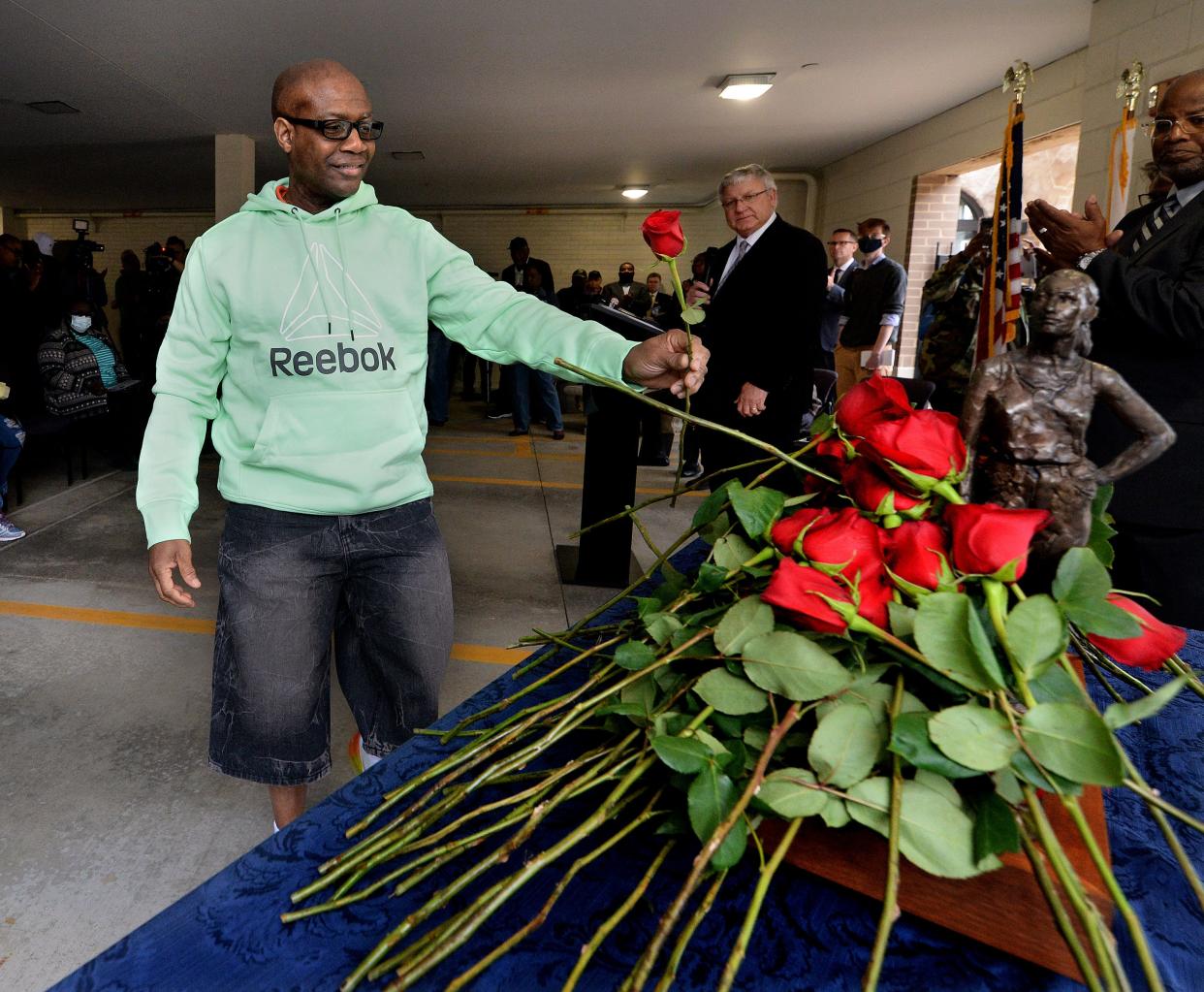 Roy Graham, the father of Deidre Silas, the state Department of Children and Family Services worker who was stabbed to death while doing her job, places a rose for workers killed on the job on a replica of the Illinois Workers Memorial statue during the annual Workers Memorial Day ceremony Thursday at the Illinois AFL-CIO Front Plaza. [Thomas J. Turney/The State Journal-Register]