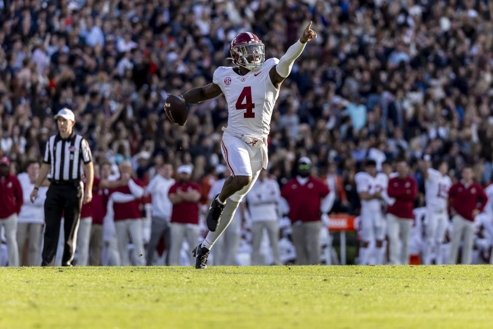 Alabama quarterback Jalen Milroe (4) signals to his receivers during the first half of an NCAA college football game against Auburn, Saturday, Nov. 25, 2023, in Auburn, Ala. (AP Photo/Vasha Hunt)