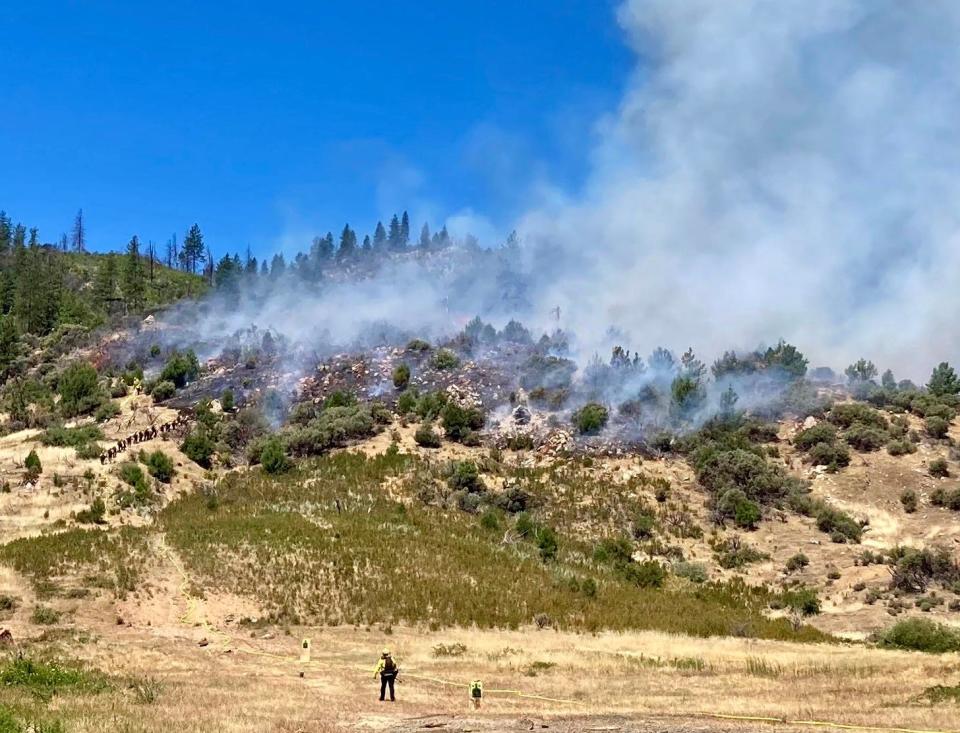 Crews fight a small fire in grass and brush off Iron Mountain Road near the Bureau of Land Management shooting range late Thursday morning, July 7, 2022.