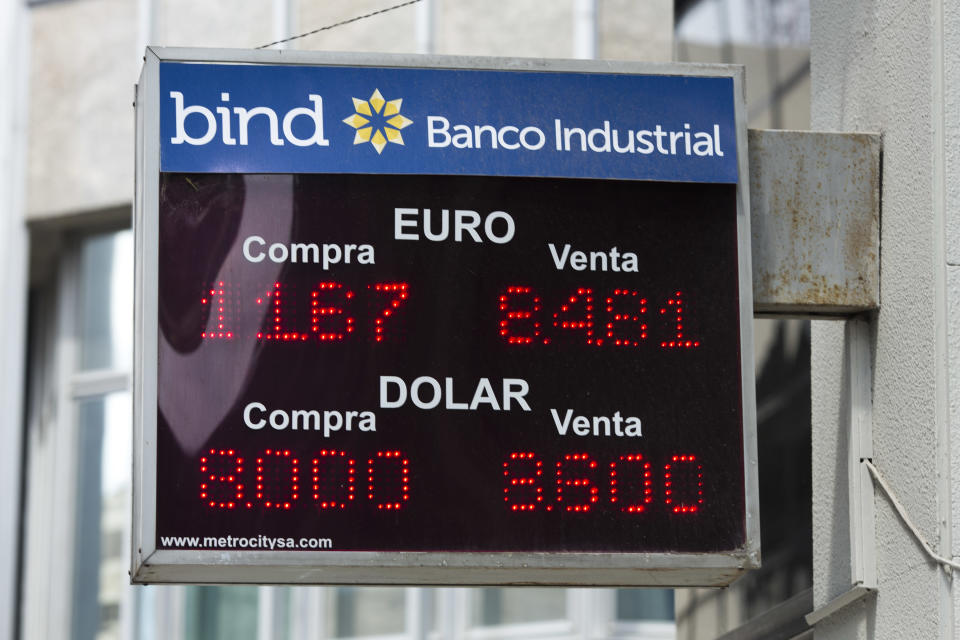 A sign outside a bank indicates the exchange rate between the Argentine peso, the Euro and the U.S. dollar in Buenos Aires, Argentina, Thursday, Jan. 23, 2014. Argentina's peso has plunged just over 17 percent in the last two days against the U.S. dollar, and economic analysts expect inflation to hit 30 percent this year. (AP Photo/Victor R. Caivano)