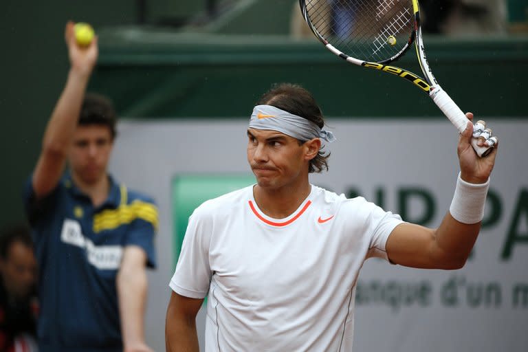 Spain's Rafael Nadal acknowledges the crowd prior to his French Tennis Open 2nd round match against Slovakia's Martin Klizan, at the Roland Garros stadium in Paris, on May 30, 2013. Defending men's champion Nadal, seeking a record eighth title, only got to warm-up for his Round 2 clash before the match was held over for a day