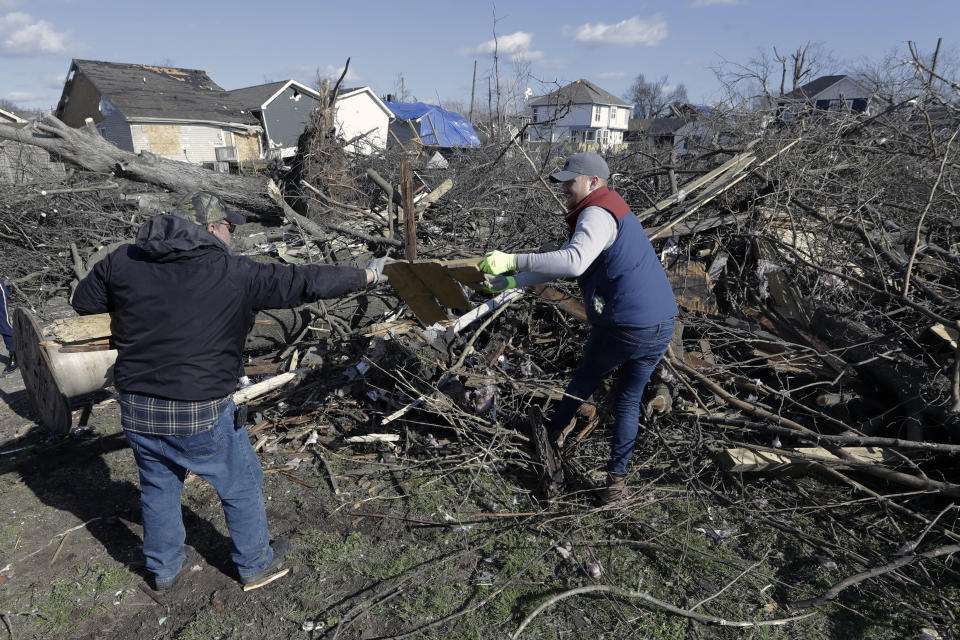 Volunteers Tony Fawbush, left, and Jim Savelyev clean up debris in a residential area Friday, March 6, 2020, in Nashville, Tenn. Residents and businesses face a huge cleanup effort after tornadoes hit the state Tuesday. (AP Photo/Mark Humphrey)