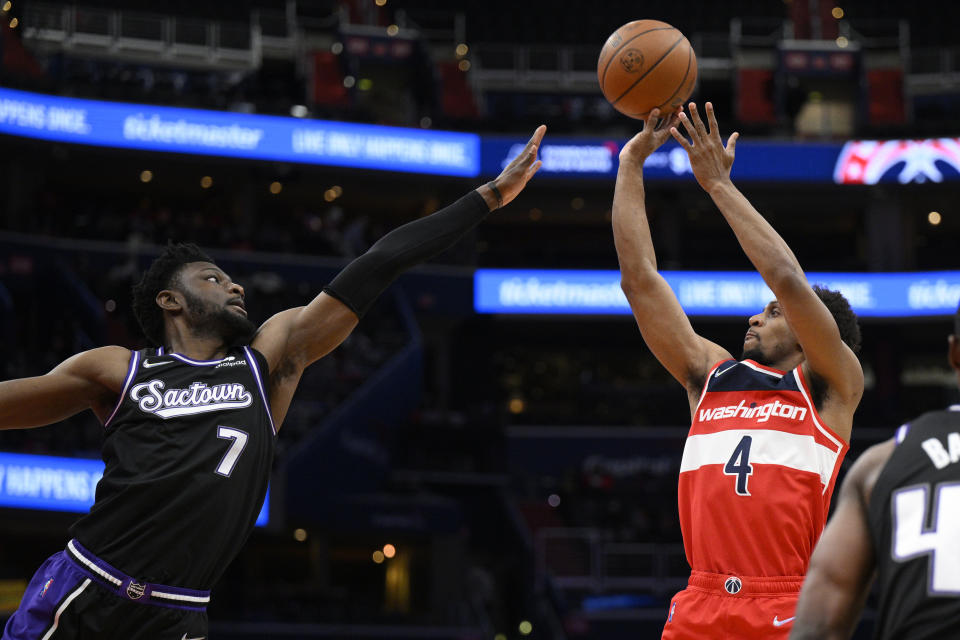 Washington Wizards guard Ish Smith (4) shoots against Sacramento Kings forward Chimezie Metu (7) during the first half of an NBA basketball game Saturday, Feb. 12, 2022, in Washington. (AP Photo/Nick Wass)