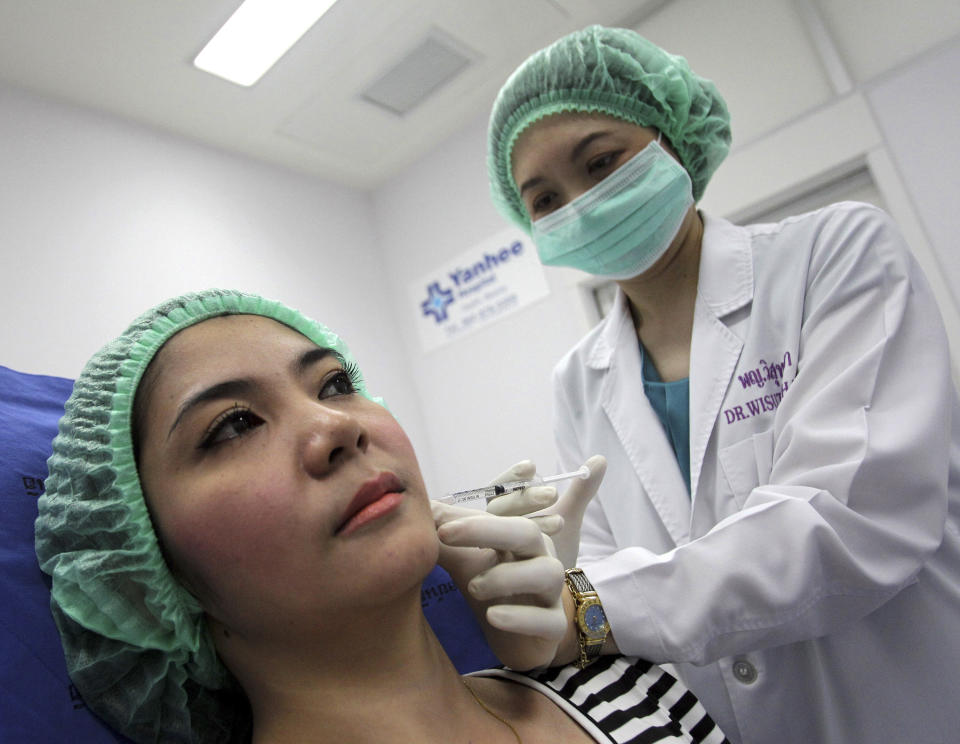 In this Oct. 17, 2012 photo, a 32-year-old Thai woman, Nisakron Boonpun, left, gets a Botox injection at Bangkok’s Yanhee Hospital, which houses one of the country’s best-known and largest beauty clinics. Bangkok has more than 500 licensed beauty clinics that cater to the wealthy but is also full of illegal, back-alley beauticians who are attracting young and working-class customers with rock-bottom prices. The recent case of a 33-year-old aspiring model who died from a botched collagen injection has drawn attention to the dark side of a booming beauty industry in Thailand. (AP Photo/Sakchai Lalit)