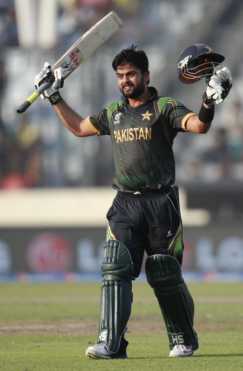 Pakistan batsman Ahmed Shehzad raises his bat and helmet to celebrate scoring a century during their ICC Twenty20 Cricket World Cup match against Bangladesh, in Dhaka, Bangladesh, Sunday, March 30, 2014. (AP Photo/Aijaz Rahi)