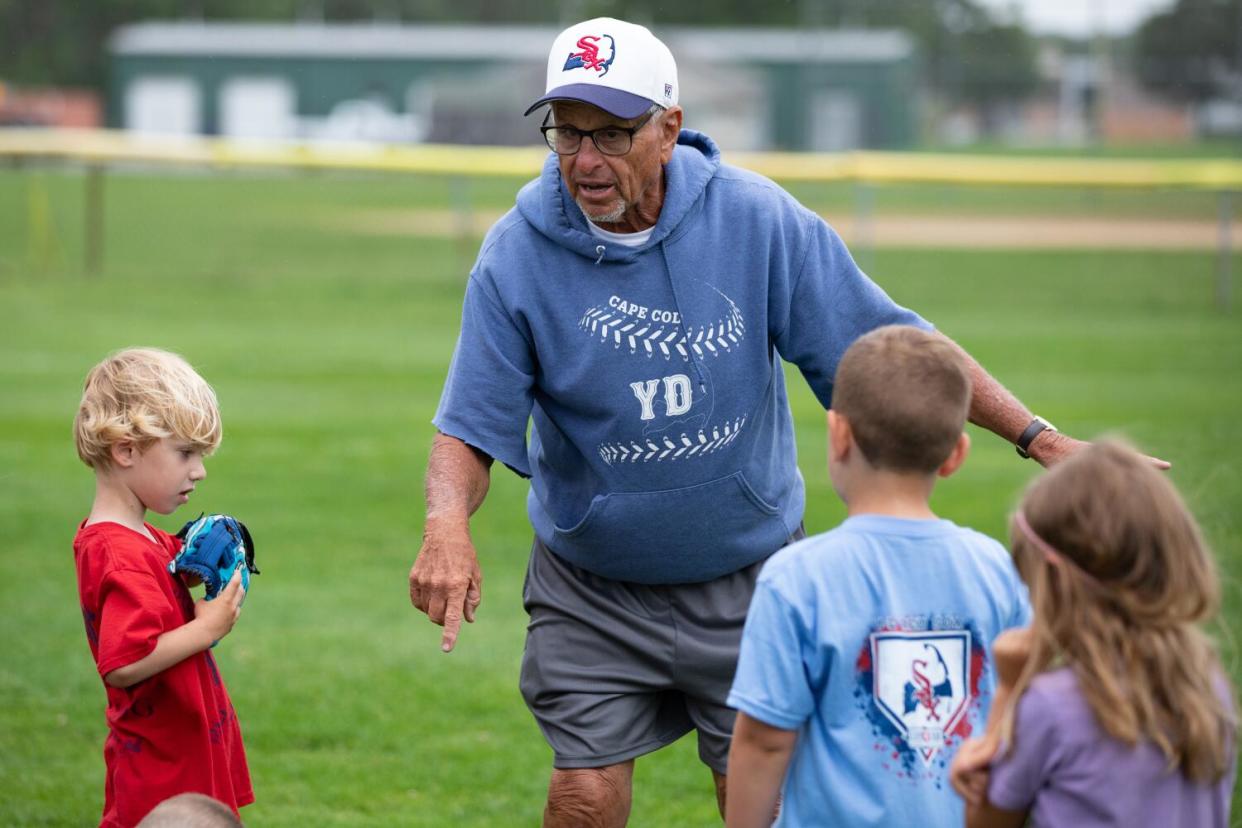 Coach Scott Pickler talks to three children.