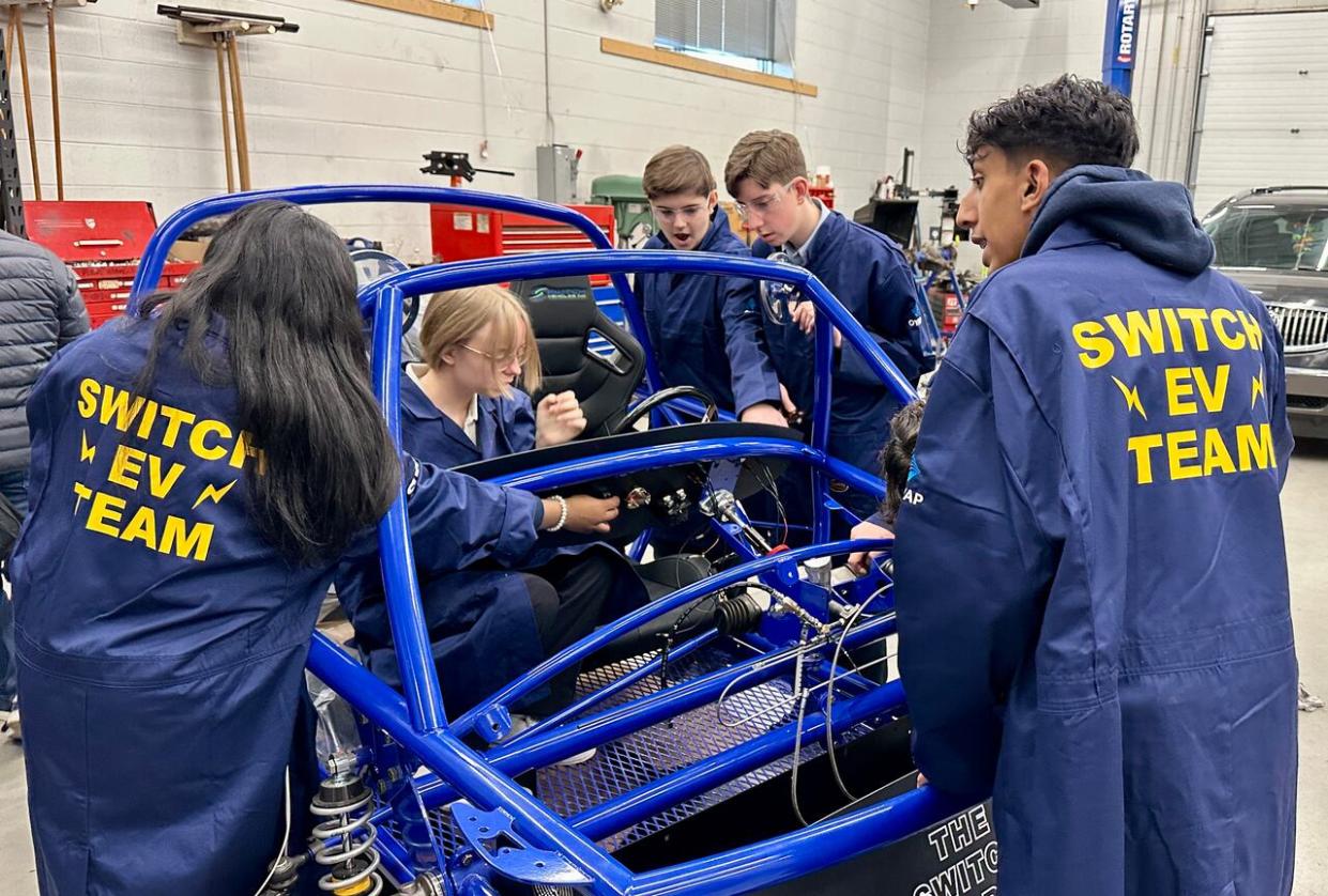 Automotive students at St. Anne Catholic High School in Lakeshore work on the school's new Switch electric vehicle kit. Photographed Dec. 14, 2023. (Dalson Chen/CBC - image credit)