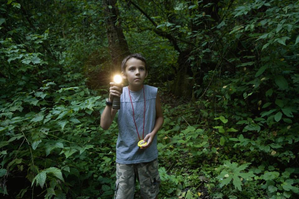 summer activities boy with torch in forest