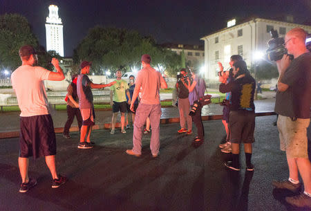 Onlookers share words as Confederate statues are removed from the south mall of the University of Texas in Austin, Texas, U.S., August 21, 2017. REUTERS/Stephen Spillman