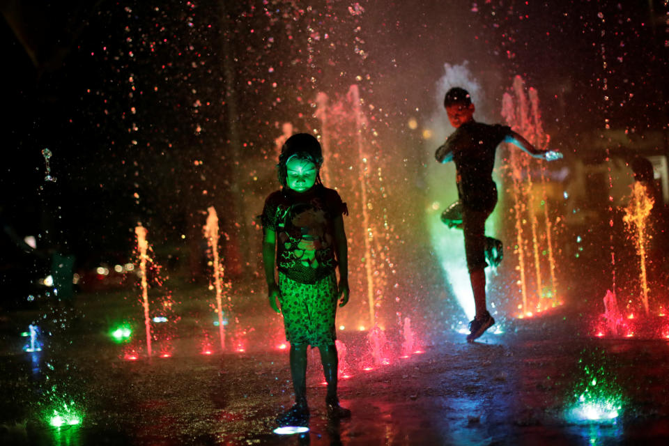 <p>Honduran children, part of a caravan of thousands of migrants from Central America en route to the United States, play with water fountains on the sidewalks of Tapachula city center, Mexico, on Oct. 21, 2018. (Photo: Ueslei Marcelino/Reuters) </p>