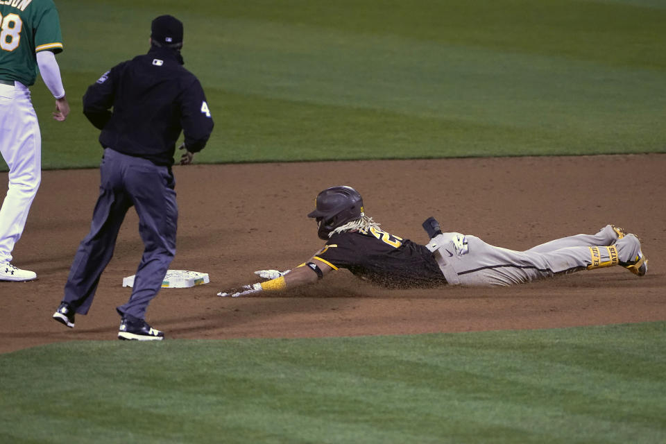 San Diego Padres' Fernando Tatis Jr., right, slides into second base on a double that scored two runs against the Oakland Athletics during the fifth inning of a baseball game in Oakland, Calif., Friday, Sept. 4, 2020. (AP Photo/Tony Avelar)