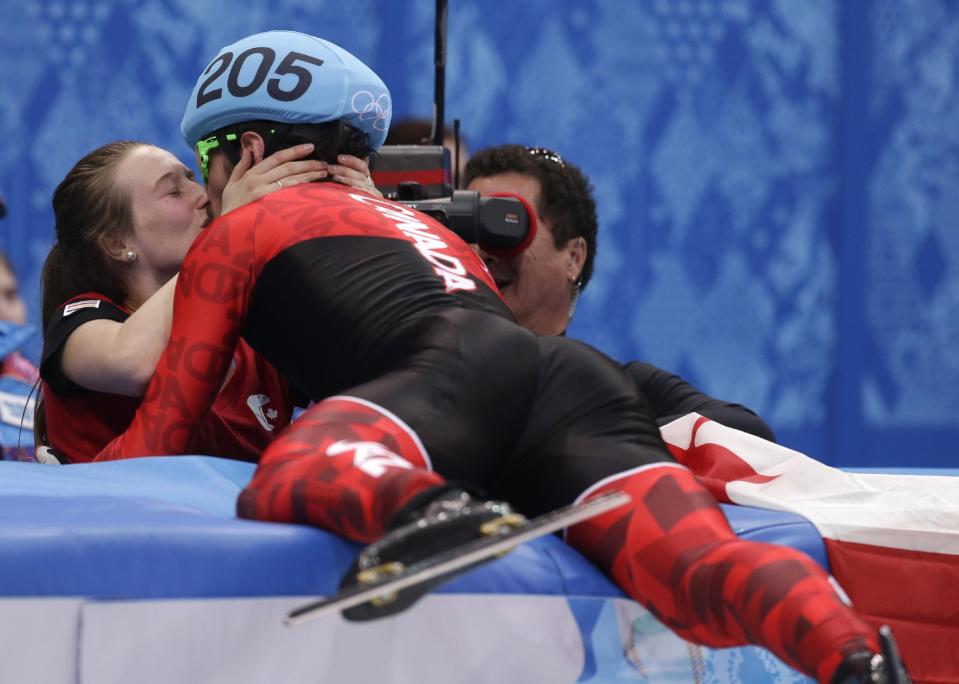 Charles Hamelin of Canada, right, embraces Marianne St. Gelais after he won the men's 1500m short track speedskating final at the Iceberg Skating Palace during the 2014 Winter Olympics, Monday, Feb. 10, 2014, in Sochi, Russia. (AP Photo/Darron Cummings)