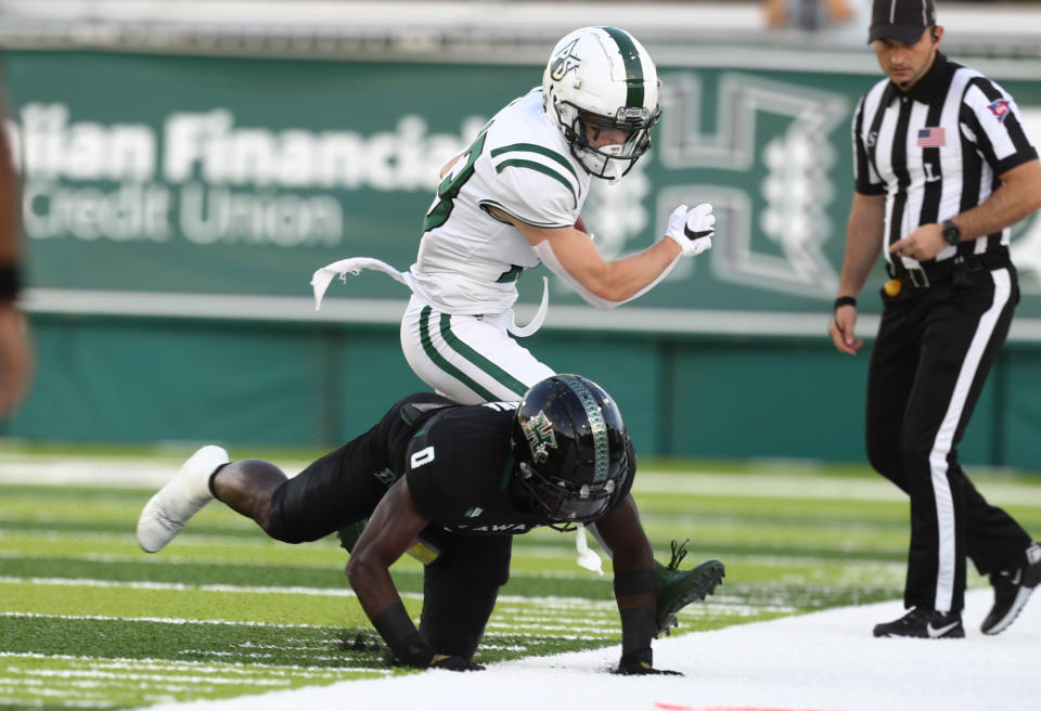 Portland State wide receiver Beau Kelly (13) is tackled on the sideline by Hawaii defensive back Chima Azunna (0) after making a catch during the first half of an NCAA college football game, Saturday, Sept. 4, 2021, in Honolulu. (AP Photo/Darryl Oumi)