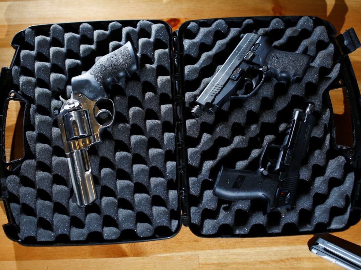Three handguns are displayed at a gun owner's home after Canada's government introduced legislation to implement a 'national freeze' on the sale and purchase of handguns, as a part of a gun control package that would also limit magazine capacities and ban some toys that look like guns, in New Westminster, B.C. (Jesse Winter/Reuters - image credit)